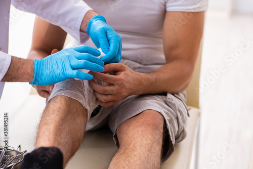 Leg injured man visiting old doctor in first aid concept