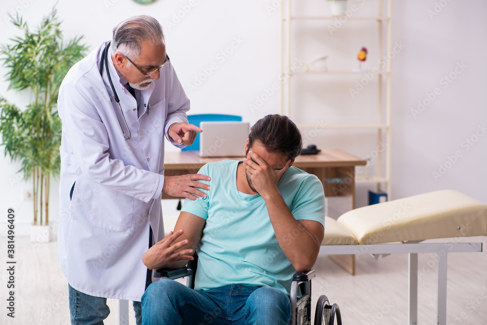 Experienced doctor and young male patient in wheel-chair Experienced doctor and young male patient in wheel-chair