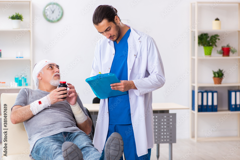Young male doctor and old patient in first aid concept Young male doctor and old patient in first aid concept