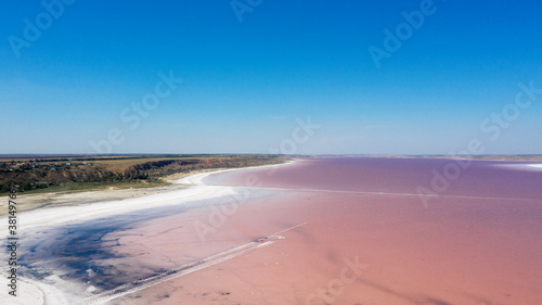 Aerial drone top down photo of a natural pink lake Kuyalnik in Odessa, Ukraine. Lake naturally turns pink due to salts and small crustacean Artemia in the water. This miracle is rare occurrence.