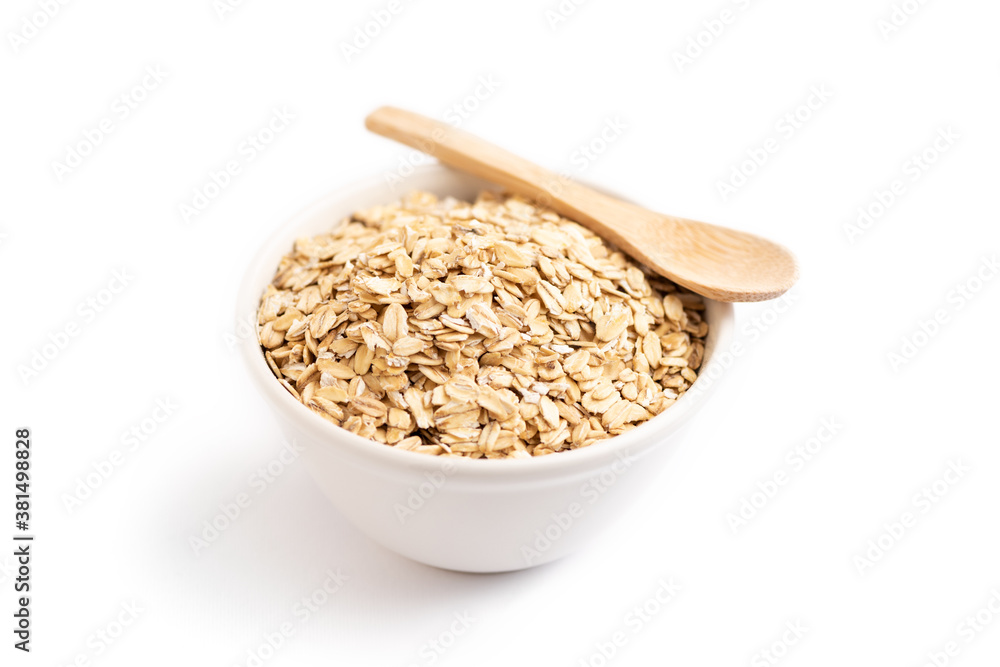 Oat flakes on a bowl and a wooden spoon Oat flakes on a bowl and a wooden spoon