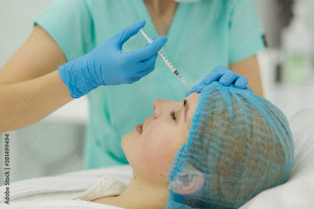 Hands of cosmetologist making injection in face, lips. Young woman gets beauty facial injections in beaty clinic. Face aging, rejuvenation and hydration procedures. Aesthetic cosmetology. Beauty salon Hands of cosmetologist making injection in face, lips. Young woman gets beauty facial injections in beaty clinic. Face aging, rejuvenation and hydration procedures. Aesthetic cosmetology. Beauty salon