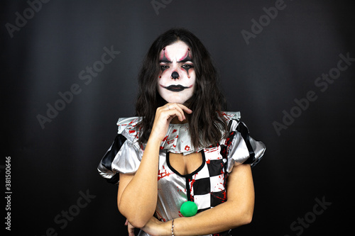 woman in a halloween clown costume over isolated black background thinking looking tired and bored with crossed arms