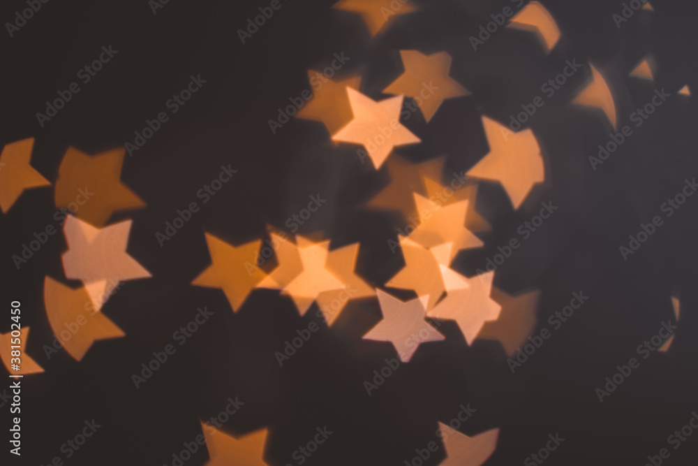 Defocused abstract bokeh lights christmas star shape at black background. orange, gold and black colors. christmas and new year concept Defocused abstract bokeh lights christmas star shape at black background. orange, gold and black colors. christmas and new year concept