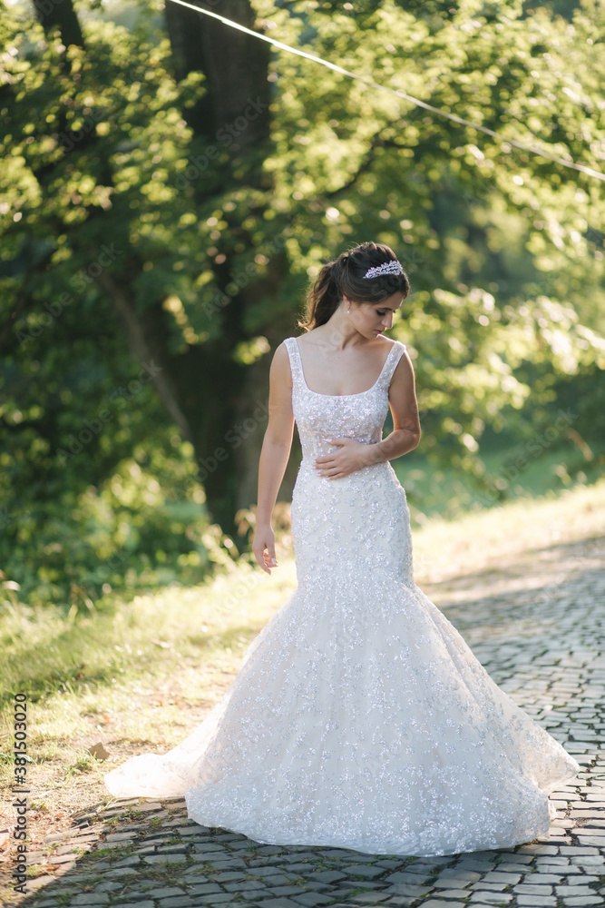 Young female model in wedding dress outdoors. Fashion photo of bride Young female model in wedding dress outdoors. Fashion photo of bride