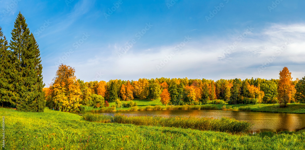 Panorama of the autumn Park. Beautiful autumn landscape with red trees by the lake.