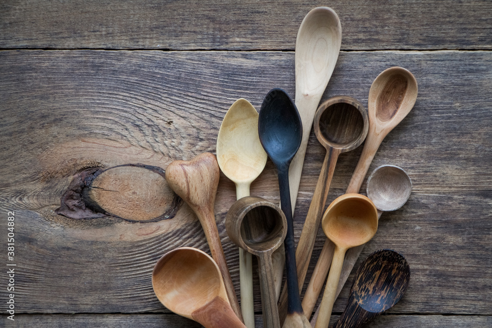 Top view lot of wooden spoons made of precious wood on wooden table, eco-friendly concept of cutlery, handmade tableware production Top view lot of wooden spoons made of precious wood on wooden table, eco-friendly concept of cutlery, handmade tableware production