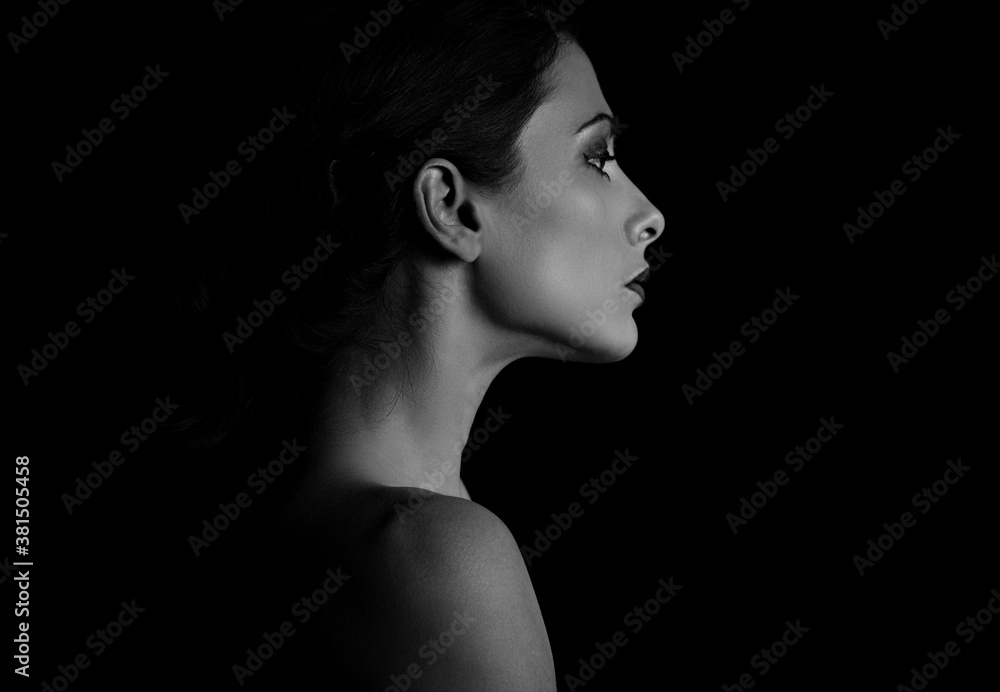 Beautiful woman with elegant healthy neck, nude back and shoulder on black background with empty copy space. Closeup profile view portrait. Art.Expression