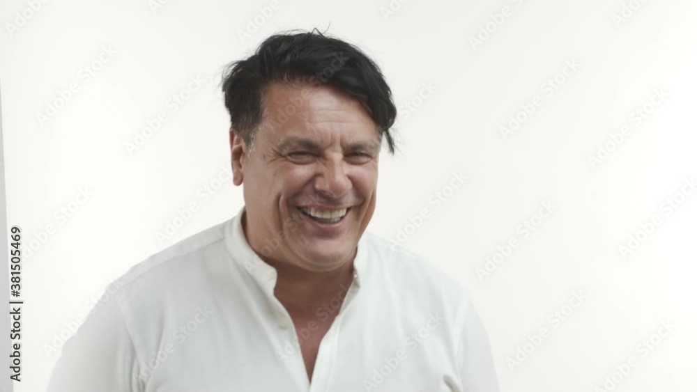 Close-up of handsome plump middle-aged guy starting to laugh, smiling and looking happy, standing over white background Close-up of handsome plump middle-aged guy starting to laugh, smiling and looking happy, standing over white background
