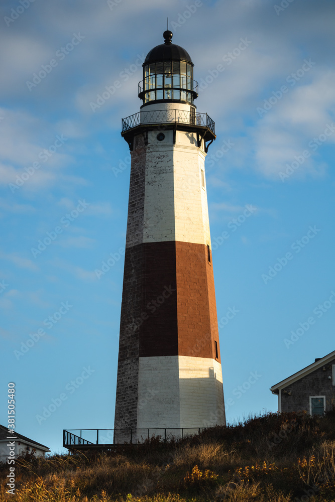 Golden sunset light hitting the side of a tall stone lighthouse. Montauk Point, New York Golden sunset light hitting the side of a tall stone lighthouse. Montauk Point, New York