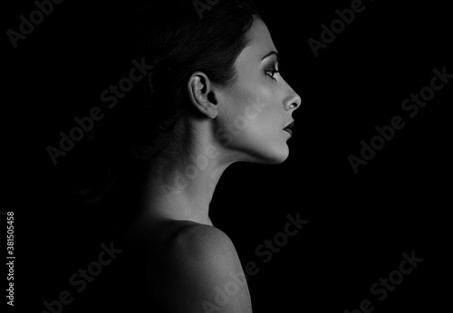 Beautiful woman with elegant healthy neck, nude back and shoulder on black background with empty copy space. Closeup profile view portrait. Art.Expression