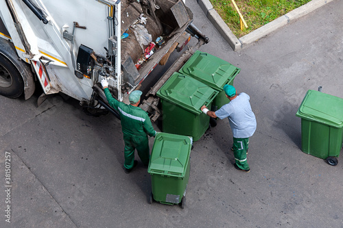 garbage men loading household rubbish in garbage truck, view from above