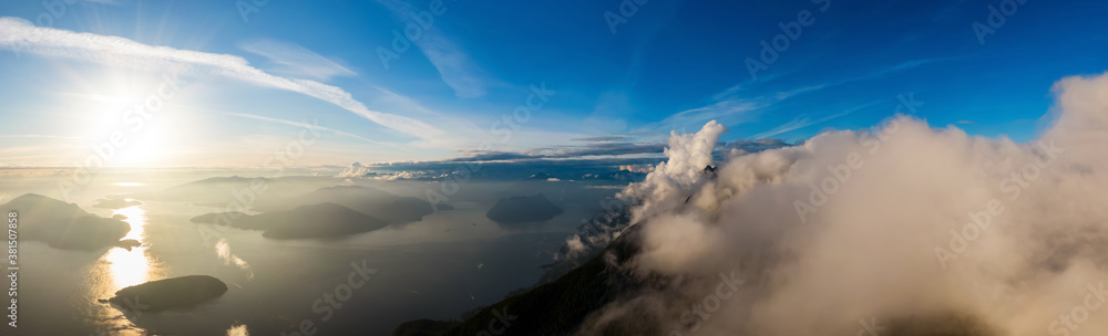 Beautiful Aerial Panoramic View of Canadian Mountain Landscape during a colorful sunny sunset. Taken at Howe Sound, West Vancouver, British Columbia, Canada. Nature Background Panorama