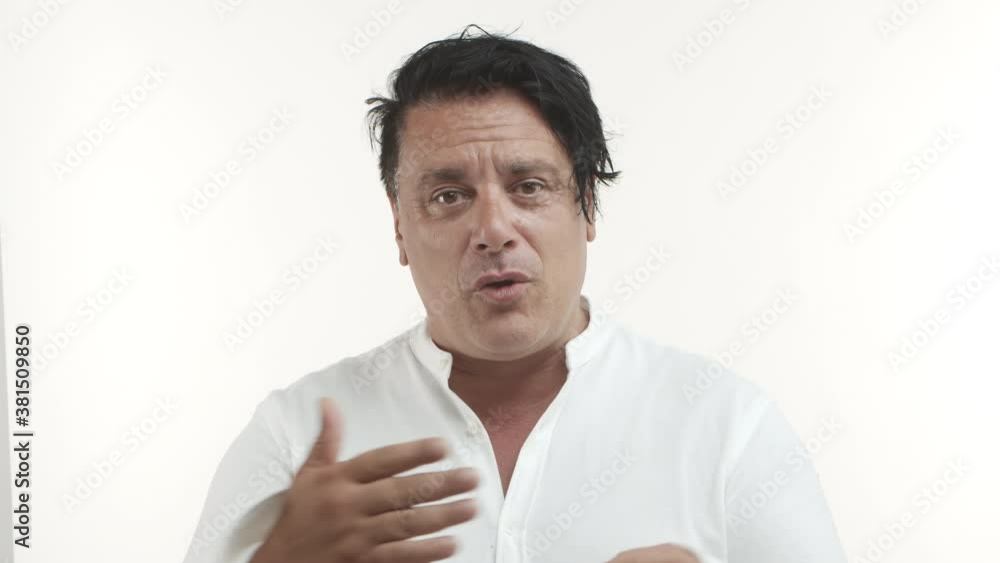 Close-up of middle-aged italian man in white casual t-shirt asking for last chance, explaining himself and showing number one, standing over white background Close-up of middle-aged italian man in white casual t-shirt asking for last chance, explaining himself and showing number one, standing over white background