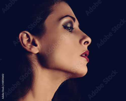 Beautiful makeup woman with elegant healthy neck, nude back and shoulder on black background with empty copy space. Closeup profile view portrait. Art.