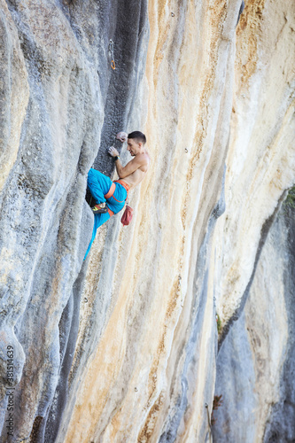 Caucasian man climbing challenging route on cliff