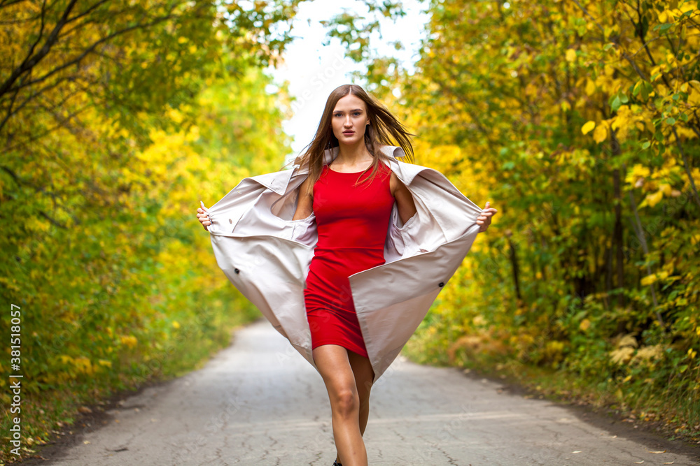 Young woman in red tight dress posing in autumn forest Young woman in red tight dress posing in autumn forest
