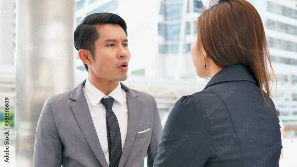Confident asian trader explaining something to his colleague while coming back from work. Confident asian trader explaining something to his colleague while coming back from work.
