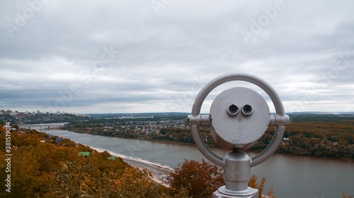 binoculars on the observation deck.mountain view of the city and autumn forest.