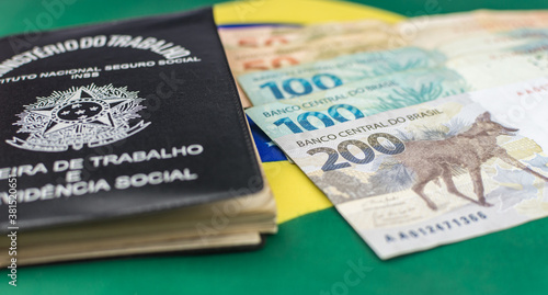 new note of two hundred Brazilian reais with some parts in focus and a blurred part on top of the flag of Brazil