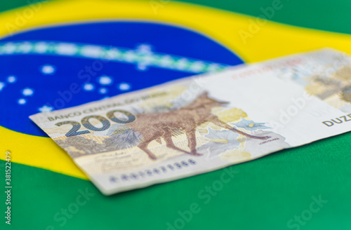 new Brazilian money new note of two hundred Brazilian reais with some parts in focus and a blurred part on top of the flag of Brazil