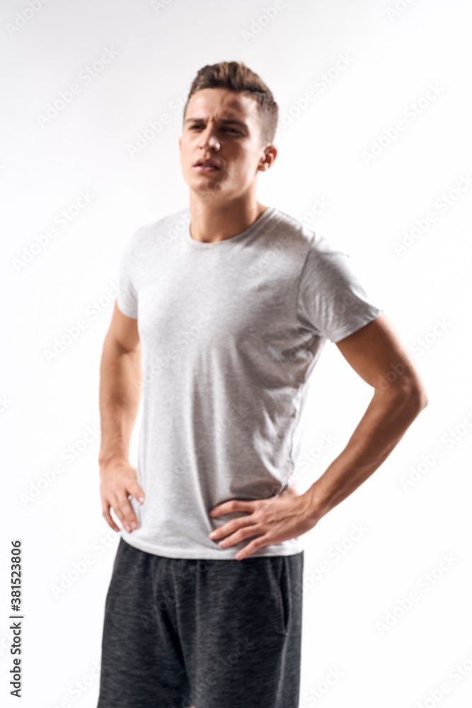 sporty man in white t-shirt on a light background gesturing with his hands cropped view Copy Space sporty man in white t-shirt on a light background gesturing with his hands cropped view Copy Space