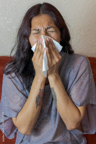 sick woman blowing their no se from mexico  photo