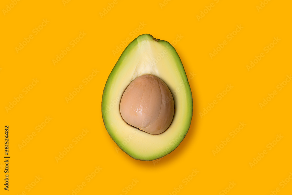 Half fresh avocado on yellow background Half fresh avocado on yellow background