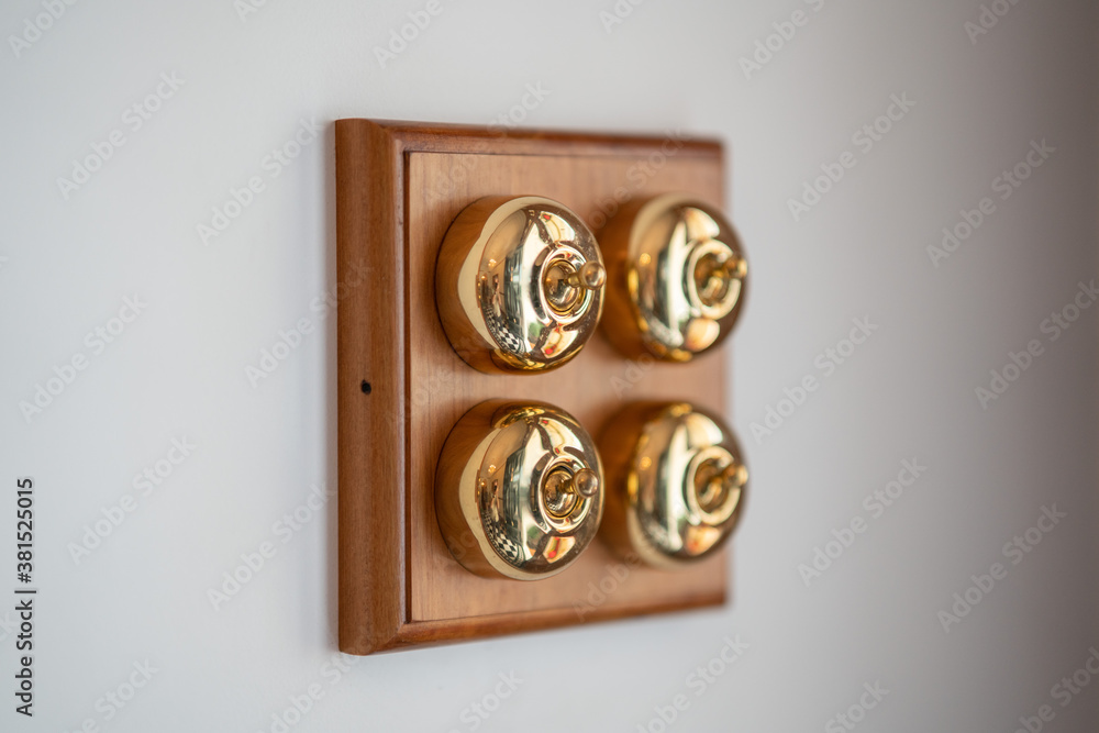 Old school brass light switches on wooden panel Old school brass light switches on wooden panel
