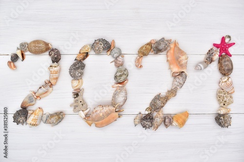 New year 2021, Christmas, made of seashells on a white wooden background. Texture, design, decor, creative, greeting card. photo