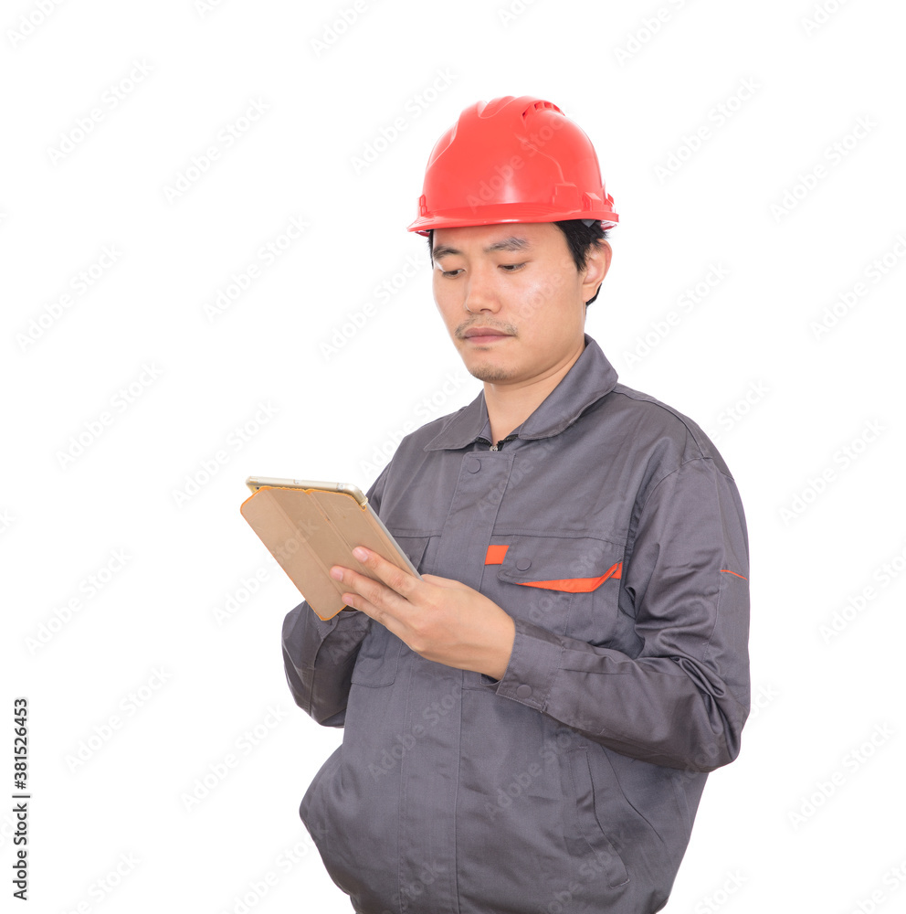 Construction worker with red hard hat holding ipad in hand standing in front of white background Construction worker with red hard hat holding ipad in hand standing in front of white background