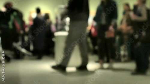 View of people walking during an art gallery exhibition visit. Background with an intentional blur effect applie. 4K