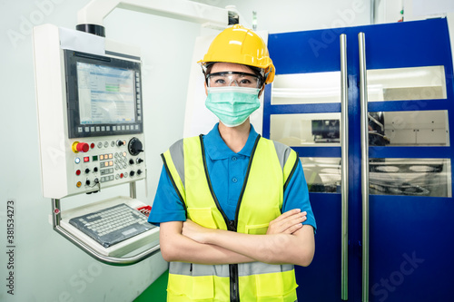 Asian female worker standing, crossed arms and wearing safety wears.