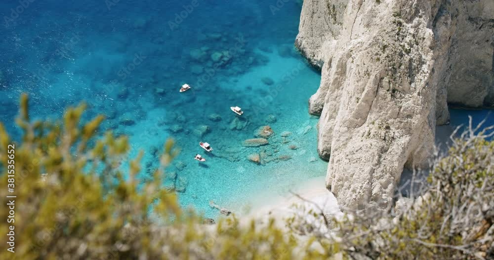 Zakynthos island, Greece. Amazing beach near Keri rock. Blue lagoon with tourist pleasure boats. Top view framed by foliage Zakynthos island, Greece. Amazing beach near Keri rock. Blue lagoon with tourist pleasure boats. Top view framed by foliage