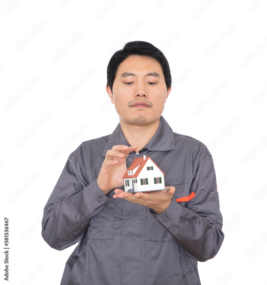 Young Chinese worker in overalls holding a small house model Young Chinese worker in overalls holding a small house model