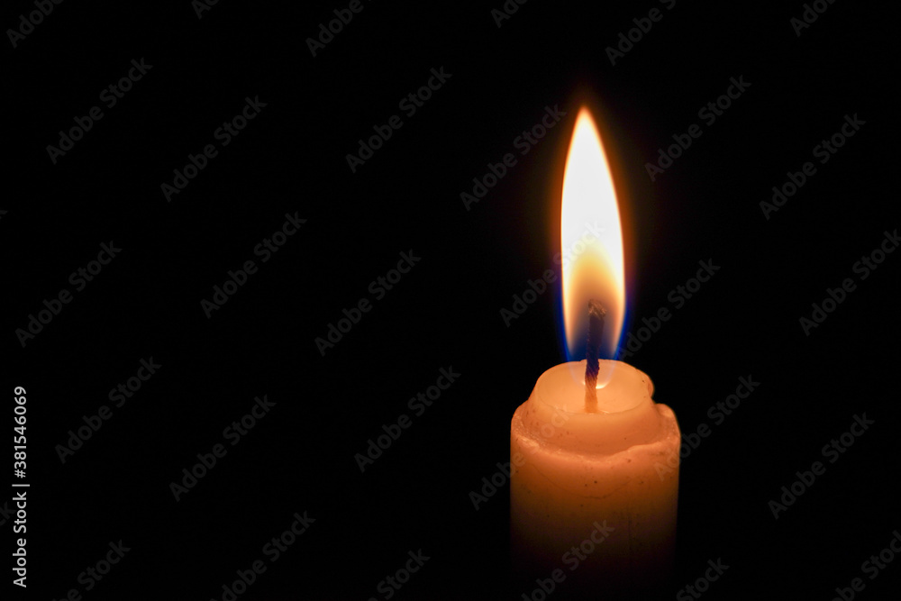 A single candlelight burning in the dark, close up photo of a candle in the night. A single candlelight burning in the dark, close up photo of a candle in the night.