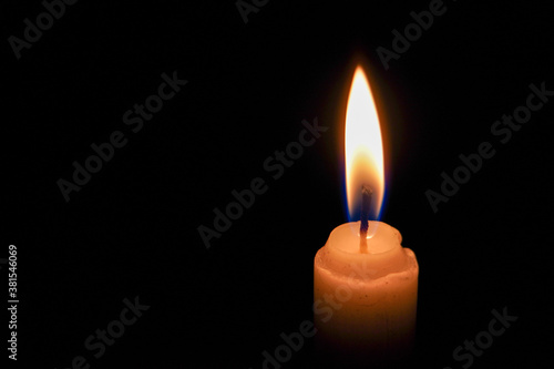 A single candlelight burning in the dark, close up photo of a candle in the night.