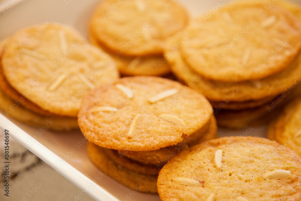 A plate full of delicious cookies with Almond slivers on top A plate full of delicious cookies with Almond slivers on top