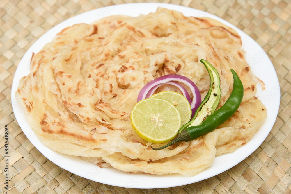 Indian flat bread Kerala porotta, Malabar porotta, paratha layered bread made of whole wheat flour or Maida, India. chapathi, fulka, parantha ,rumali roti served with side dish meat curry. Indian flat bread Kerala porotta, Malabar porotta, paratha layered bread made of whole wheat flour or Maida, India. chapathi, fulka, parantha ,rumali roti served with side dish meat curry.