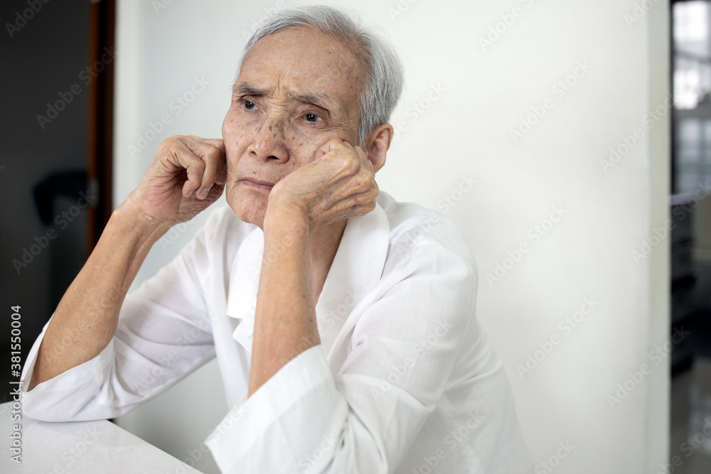 Bored senior woman is propped her cheeks with hands,sad facial expression,spending home alone,asian elderly people thinking having question feeling weary or lacks interest in the care from her family Bored senior woman is propped her cheeks with hands,sad facial expression,spending home alone,asian elderly people thinking having question feeling weary or lacks interest in the care from her family