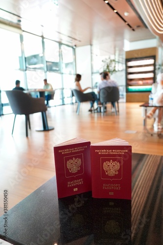 Passports to world travel. Travel design. Two red passports is on the table is ready for check-in in the lounge of airport. Two Russian passports on the background of the airport lounge