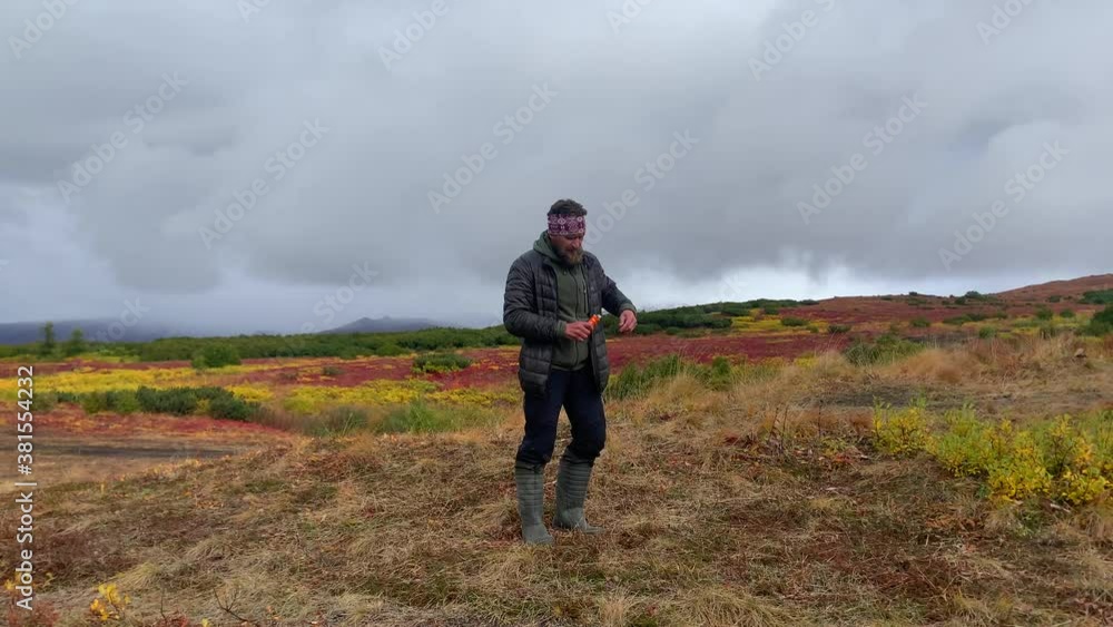 A man lights a signal fire in a field. Trekking in Klyuchevskoy volcano park. Travel to the Kamchatka Peninsula. A man lights a signal fire in a field. Trekking in Klyuchevskoy volcano park. Travel to the Kamchatka Peninsula.
