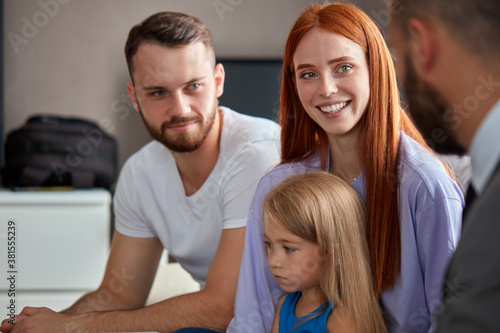 redhead woman with husband and daughter emotionally talk about their problems to psychologist, therapist. they sit in the office discussing