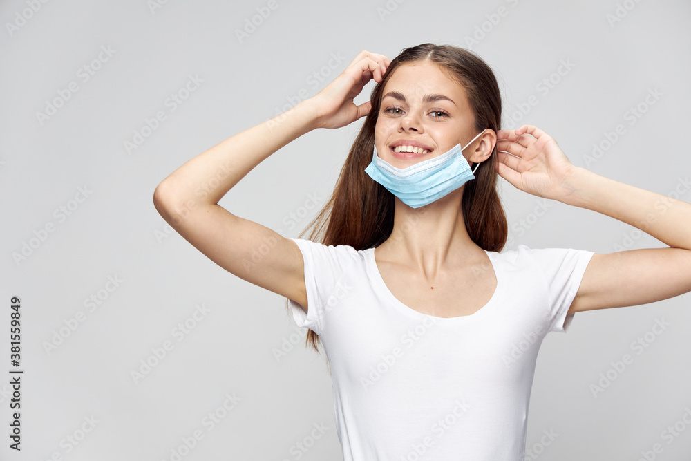 Woman in medical mask smile hands near face white t-shirt 