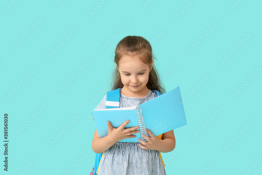 Little schoolgirl with book on color background Little schoolgirl with book on color background
