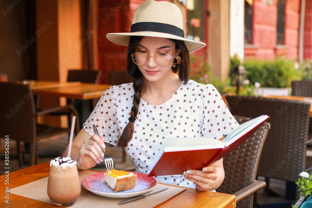 Beautiful young woman reading book in street cafe Beautiful young woman reading book in street cafe