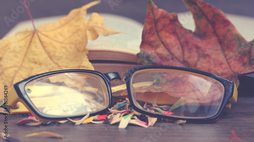 Broken yellow glasses so close and autumn leaves