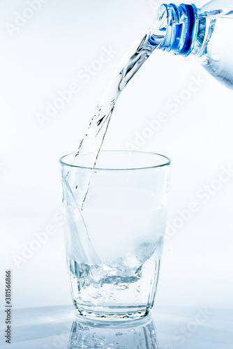 ペットボトルから透明なガラスのコップに注がれる水