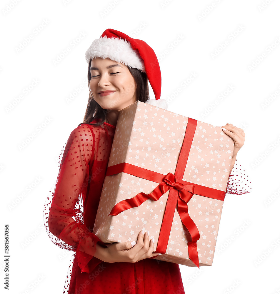 Happy young woman in Santa hat and with Christmas gift on white background Happy young woman in Santa hat and with Christmas gift on white background