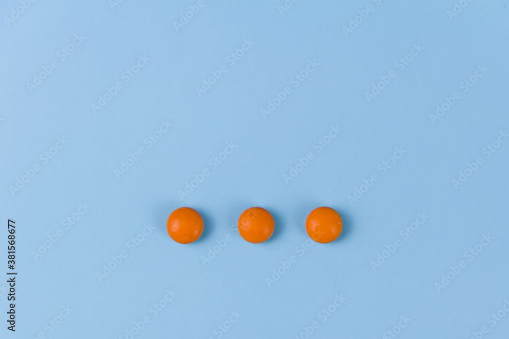 Naklejka three orange pills on a blue background